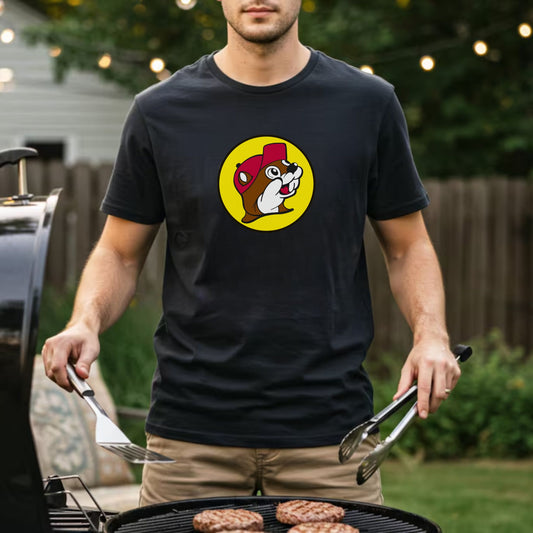 Man grilling outdoors wearing a black t-shirt with a bucee beaver graphic.
