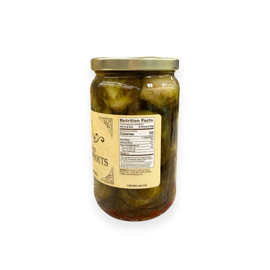 Buc-ee's Spicy Pickled Brussels Sprouts 16 fl oz glass jar side view showing nutrition facts label, green Brussels sprouts in spicy brine with red pepper pieces, and golden yellow vintage-style labeling