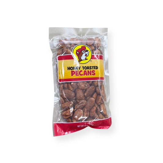 Buc-ee's Honey Toasted Pecans 12 oz clear plastic bag front view featuring iconic red beaver mascot logo, "HONEY TOASTED PECANS" text, and visible honey-roasted pecans through clear packaging