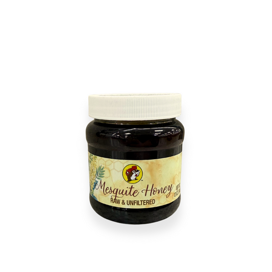 Buc-ee's Mesquite Honey 12 oz jar front view featuring iconic red beaver mascot logo, "Mesquite Honey" text with desert plant graphics, "RAW & UNFILTERED" designation, and white screw-on lid