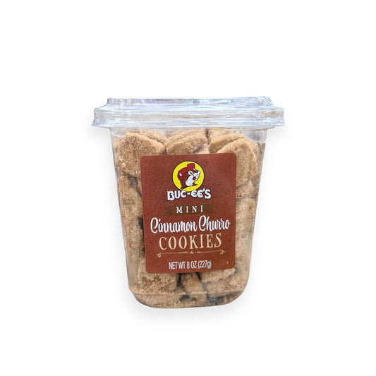 Buc-ee's Mini Cinnamon Churro Cookies 8 oz clear container front view featuring brown churro-themed label with beaver mascot logo, "MINI Cinnamon Churro COOKIES" text, and visible golden cinnamon-coated mini cookies inside container