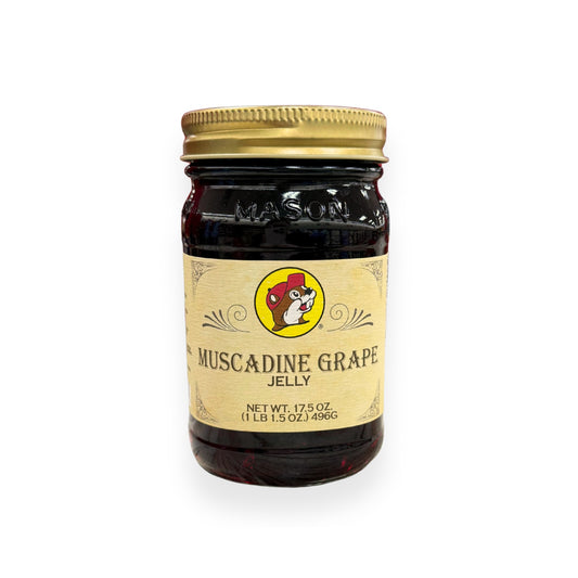 Buc-ee's Muscadine Grape Jelly 17.5 oz mason jar front view featuring iconic red beaver mascot logo, "MUSCADINE GRAPE JELLY" text, and classic mason jar styling with golden lid